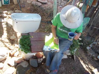 Taking a break on a bench made from wood plank between two garden toilets